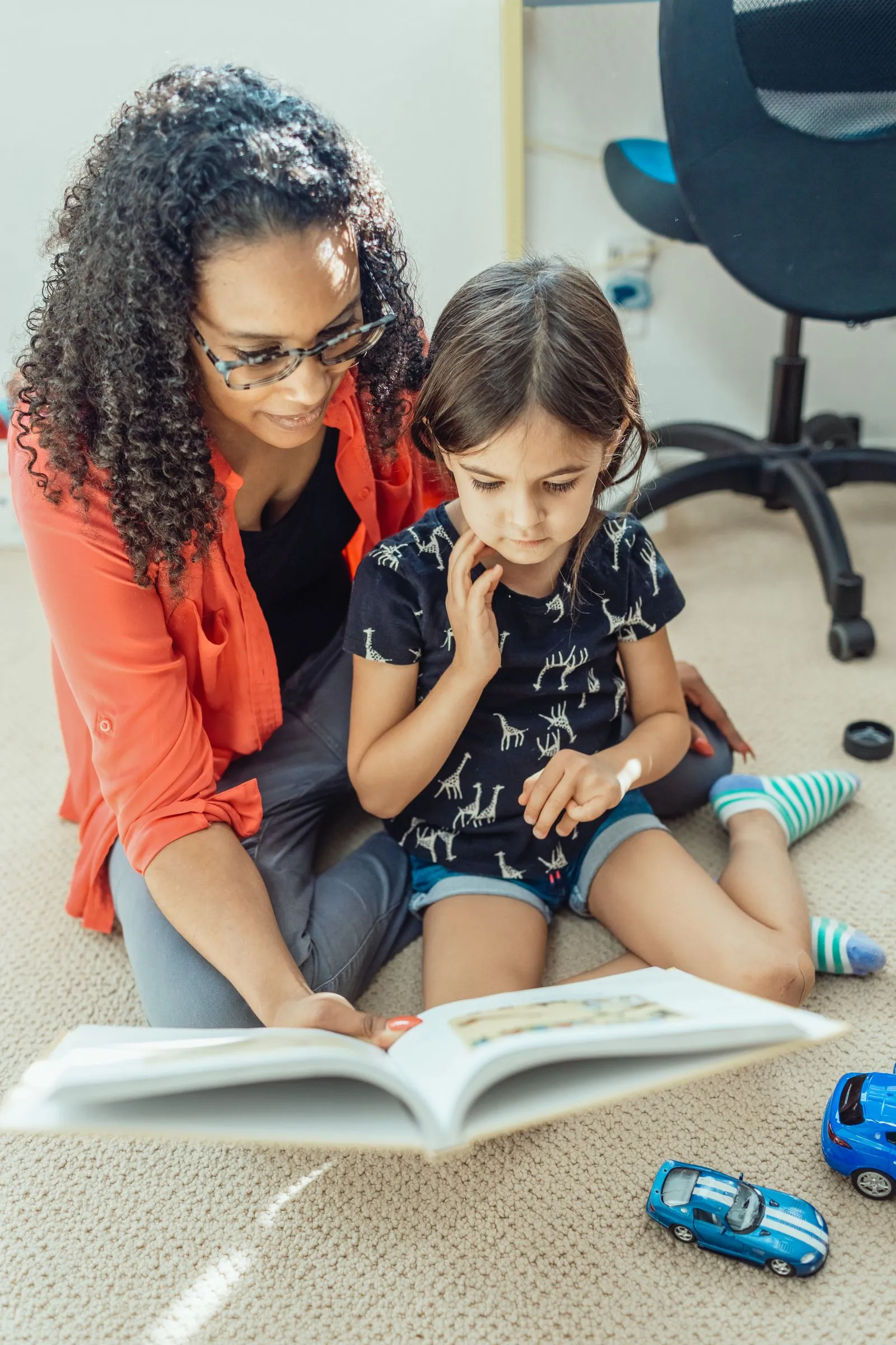A mother and daughter reading a book together at home